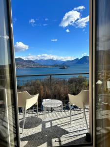 a balcony with a table and chairs and a view of the water at Suite in Baveno