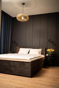 a bedroom with a bed and a black wall at Apartament No1 Wyszyńskiego in Wrocław