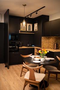 a kitchen with a table and some chairs in a room at Apartament No1 Wyszyńskiego in Wrocław