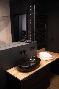 baño con lavabo negro y espejo en Apartament No1 Wyszyńskiego, en Wroclaw