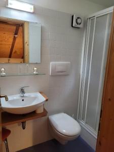 a white bathroom with a toilet and a sink at Gassermühle-Ferienhaus in Eggen