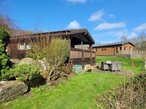 a house with a garden and a building at Immaculate 2-Bed Lodge Next To Lake in Preston
