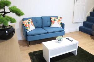 a living room with a blue couch and a coffee table at Peaceful 2 Bed House FREE WiFi and Parking in Belle Isle
