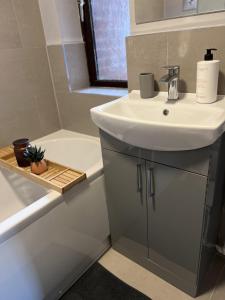 a bathroom with a sink and a toilet and a tub at Reading City Centre - Free Parking - Franklin Suite in Reading