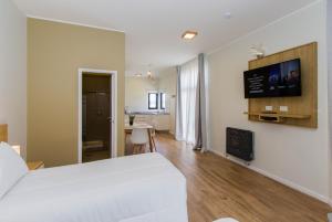 a bedroom with a white bed and a room with a table at Criollos Apartamentos in Ushuaia