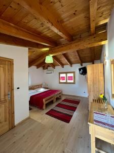 a bedroom with a red bed and a wooden ceiling at Mrizi i Zanave Agroturizëm in Lezhë