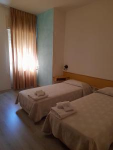 duas camas num quarto de hotel com toalhas em Hotel Colibrì em Alessano