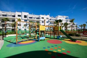 um parque infantil em frente a um grande edifício de apartamentos em Apartamento Aguacate beach playa Granada em Motril