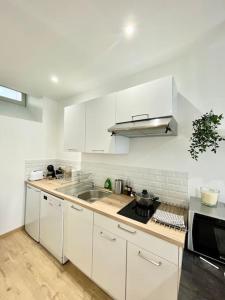 kuchnia z białymi szafkami i zlewem w obiekcie Hyper centre appartement Cosy WIFI w mieście Rodez +16 zdjęć