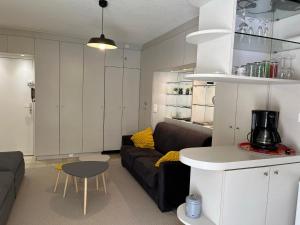 uma sala de estar com um sofá e uma mesa em Studio en rez de jardin plage de Portissol em Sanary-sur-Mer