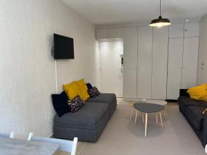 uma sala de estar com um sofá e uma mesa em Studio en rez de jardin plage de Portissol em Sanary-sur-Mer