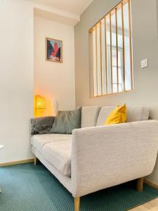 salon z kanapą i oknem w obiekcie Hyper centre appartement Cosy WIFI w mieście Rodez
