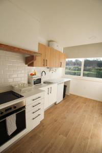 een keuken met witte apparatuur en houten vloeren bij Oriente DNA Studios X in Lissabon
