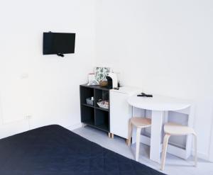 um quarto com uma mesa branca e dois bancos e uma mesa branca em [Parco M. Claro] Matrimoniale con Bagno Privato. em Cagliari
