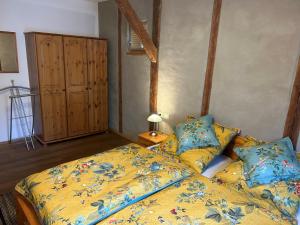 1 dormitorio con 1 cama con edredón amarillo en Ferienhaus Ausonius, en Neumagen-Dhron