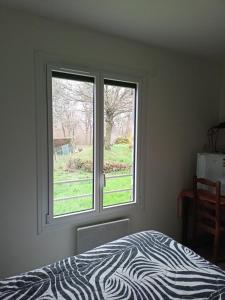 a bedroom with a zebra print bed and a window at Brigitte Carbonnel in Aydat