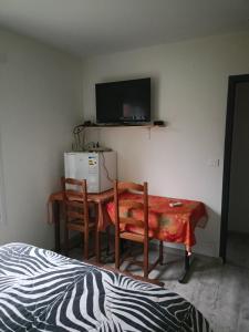 a room with a table and two chairs and a television at Brigitte Carbonnel in Aydat