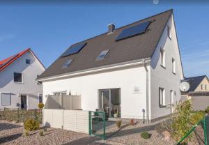 een wit huis met zonnepanelen op het dak bij Ferienhaus Wellenreiter in Zierow