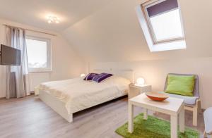 a bedroom with a bed and a tv and a chair at Ferienhaus Wellenreiter in Zierow