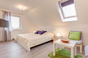 een slaapkamer met een bed, een tv en een stoel bij Ferienhaus Wellenreiter in Zierow