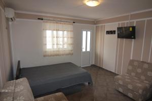 een kamer met een bed, een bank en een raam bij Apartments in villa Viktoria in Sutomore