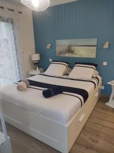 1 dormitorio con 1 cama grande y paredes azules en Studio les jardins de la brèche en Hermanville-sur-Mer