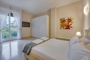 a bedroom with a large white bed and a tv at Milan Royal Suites - Centro in Milan
