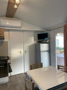 a kitchen with a white counter top and a refrigerator at Mobil home 6 à 8 personnes SANS Fun Pass in Canet-en-Roussillon