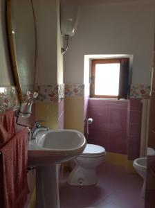 a bathroom with a sink and a toilet and a mirror at Villa Maria Antonietta in Vietri sul Mare