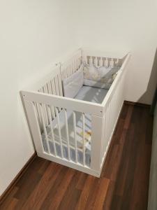 a white crib in the corner of a room at Apartment Luki in Povile