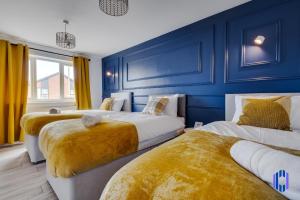 2 camas en una habitación con paredes azules y cortinas amarillas en Spacious 5 BR Home Nr Etihad Stadium with Pool Table, en Mánchester