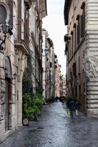 an alley with people walking down a street between buildings at Appartamento Coronari in Rome