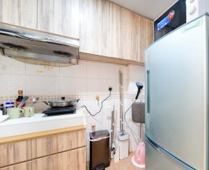 a kitchen with a refrigerator and a sink at CoLiving Space - Hennessy Road 113 Wan Chai MTR in Hong Kong