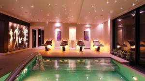 a pool in a hotel with chairs and a swimming pool at Stanley House Hotel & Spa in Blackburn
