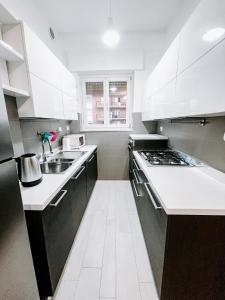 - une cuisine blanche avec évier et cuisinière dans l'établissement MYHOUSE INN SUITE PARADISO - Affitti Brevi Italia, à Collegno