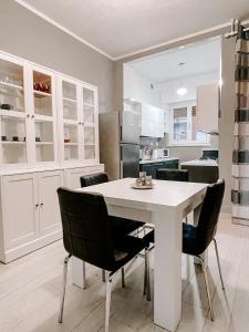 a kitchen with a white table and black chairs at MYHOUSE INN SUITE PARADISO - Affitti Brevi Italia in Collegno