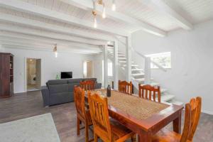 a dining room with a table and chairs and a couch at Villa Rosa Kringa in Tinjan