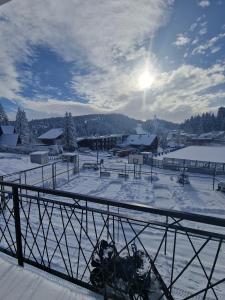 a snow covered ski slope with the sun in the sky at Apartments and Rooms Ski in Vlasic