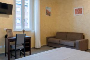 - une chambre avec un canapé et un bureau avec une chaise dans l'établissement Leader Apartment 4, à Milan