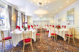 a banquet room with tables and chairs and a chandelier at The George Hotel in Wallingford