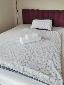 a bed with a white comforter on top of it at Jelly Apartment in Visoko