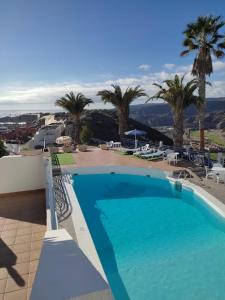 een zwembad in een resort met palmbomen bij Residence Vista Golf in Mogán