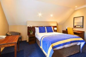 a hotel room with a bed and a desk at The George Hotel in Wallingford