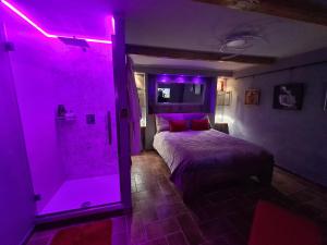 una camera con doccia illuminata dal viola e un letto di Onlyfor2 un nido d'amore per la coppia a Ronciglione