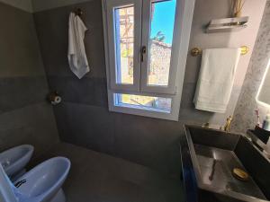 bagno con lavandino, servizi igienici e finestra di Onlyfor2 un nido d'amore per la coppia a Ronciglione