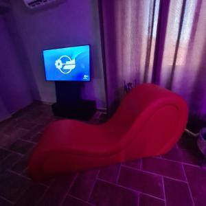 un banco rojo sentado frente a una TV en Onlyfor2 un nido d'amore per la coppia, en Ronciglione
