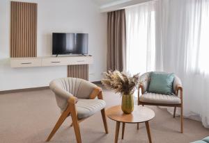 sala de estar con 2 sillas y TV en Magnolia Place, en Tivat