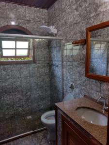 a bathroom with a shower and a sink and a toilet at Casa Temporada em Lumiar in Lumiar