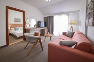 un soggiorno con divano rosso e una camera da letto di Magnolia Place a Tivat
