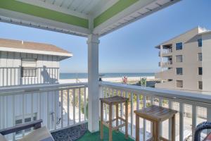 uma varanda com 2 cadeiras e vista para a praia em Breezy White Sands House Steps to Gulf Shore! em Clearwater Beach